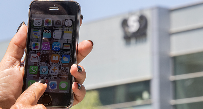 ) In this file photo taken on August 28, 2016, an Israeli woman uses her iPhone in front of the building housing the Israeli NSO group "Pegasus", in Herzliya, near Tel Aviv. JACK GUEZ / AFP