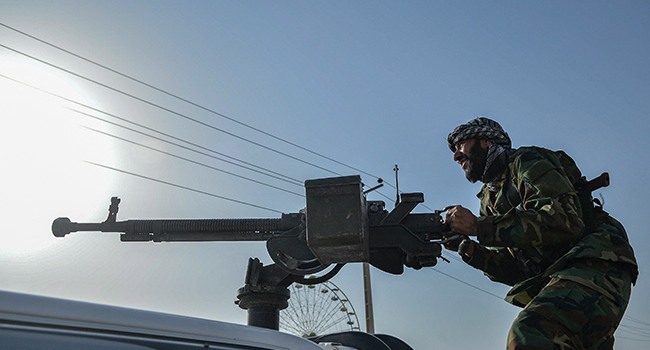 Afghan security personnel and Afghan militia fighting against Taliban, stand guard in Enjil district of Herat province on July 30, 2021. Hoshang Hashimi / AFP