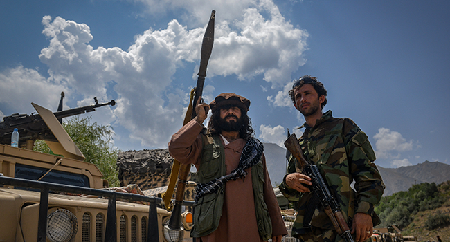 Afghan armed men supporting the Afghan security forces against the Taliban stand with their weapons and Humvee vehicles at Parakh area in Bazarak, Panjshir province on August 19, 2021. Ahmad SAHEL ARMAN / AFP