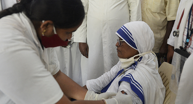 A health worker inoculates a catholic nun with the first dose of the Covaxin vaccine against the Covid-19 coronavirus during a vaccination drive at Saint Mary's Basilica in Secunderabad, the twin city of Hyderabad on August 19, 2021. NOAH SEELAM / AFP