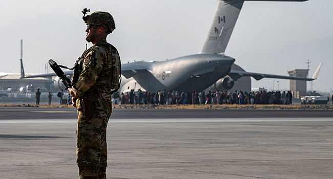 In this image courtesy of the US Air Force, a US Air Force security forces raven, assigned to the 816th Expeditionary Airlift Squadron, maintains a security cordon around a US Air Force C-17 Globemaster III aircraft in support of Operation Allies Refuge at Hamid Karzai International Airport (HKIA), Kabul, Afghanistan, on August 20, 2021. Taylor Crul / US AIR FORCE / AFP