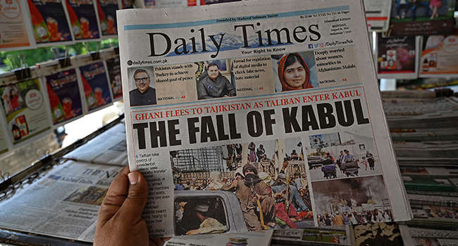 A man holds a newspaper displaying front page news about Afghanistan, at a stall in Islamabad on August 16, 2021 as the Taliban were in control of Afghanistan after President Ashraf Ghani fled the country and conceded the insurgents had won the 20-year war. Aamir QURESHI / AFP