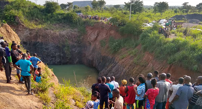 A crowd gathers at the site of an excavation pit where a vehicle was said to have plunged into on August 14, 2021.