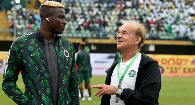 Nigeria's coach Gernot Rohr (R) speaks with Nigeria's striker Victor Osimhen before the FIFA Qatar 2022 World Cup qualification football match between Nigeria and Liberia at Teslim Balogun Stadium in Lagos, on September 3, 2021. PIUS UTOMI EKPEI / AFP