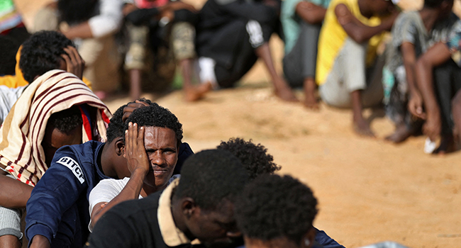 African migrants gather at a makeshift shelter in the capital Tripoli's suburb of Ain Zara, on October 11, 2021. Mahmud Turkia / AFP