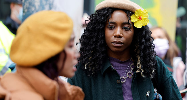 Climate activist Dominique Palmer (R) joins campaigners at a demonstration demanding that 'big finance' defunds fossil fuels, outside the headquarters of Standard Chartered bank in the City of London on October 29, 2021, Tolga Akmen / AFP