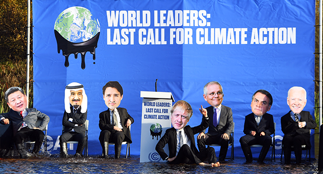 Climate change activists dressed as world leaders, including from left, Japan's Prime Minister Fumio Kishida, Saudi Arabia's King Salman bin Abdulaziz, Canada's Prime Minister Justin Trudeau, Britain's Prime Minister Boris Johnson, Australia's Prime Minister Scott Morrison, Brazil's President Jair Bolsonaro, and US President Joe Biden, pose for a photograph during a demonstration in the Forth and Clyde Canal in Glasgow on November 9, 2021, during the COP26 UN Climate Change Conference. Andy Buchanan / AFP