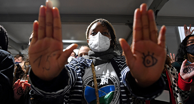 Youth climate activists, some with 1.5 written on their hands, demonstrate outside a plenary session room during the COP26 UN Climate Change Conference in Glasgow on November 10, 2021. ANDY BUCHANAN / AFP