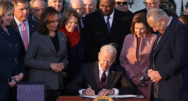 U.S. President Joe Biden signs the Infrastructure Investment and Jobs Act as he is surrounded by lawmakers and members of his Cabinet during a ceremony on the South Lawn at the White House on November 15, 2021 in Washington, DC. Alex Wong/Getty Images/AFP