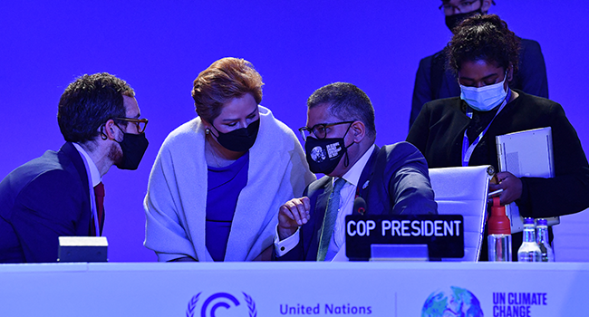 Britain's President for COP26 Alok Sharma (C) speaks with UNFCCC Executive Secretary Patricia Espinosa (2L) and other members of his team following an informal stocktaking session at the COP26 Climate Change Conference in Glasgow on November 12, 2021. Ben STANSALL / AFP