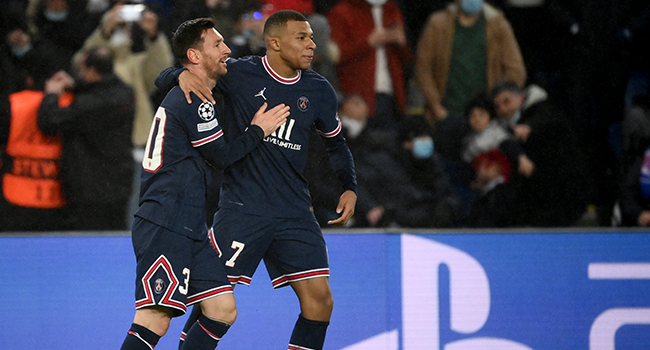 Paris Saint-Germain's Argentinian forward Lionel Messi (L) is congratulated by Paris Saint-Germain's French forward Kylian Mbappe (R) after scoring a goal during the UEFA Champions League first round day 6 Group A football match between Paris Saint-Germain (PSG) and Club Brugge, at the Parc des Princes stadium in Paris on December 7, 2021. FRANCK FIFE / AFP