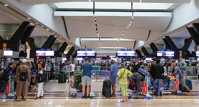 In this file photo taken on November 27, 2021 Travellers queue at a check-in counter at OR Tambo International Airport in Johannesburg on November 27, 2021, after several countries banned flights from South Africa following the discovery of a new Covid-19 variant Omicron. Phill Magakoe / AFP