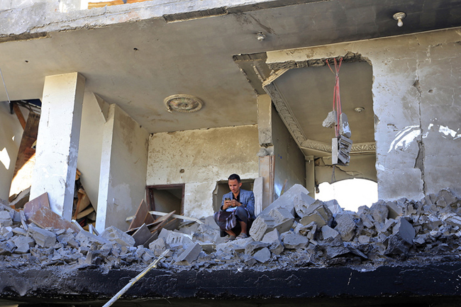 Yemenis inspect the damage following overnight air strikes by the Saudi-led coalition targeting the Huthi rebel-held capital Sanaa, on January 18, 2022. MOHAMMED HUWAIS / AFP