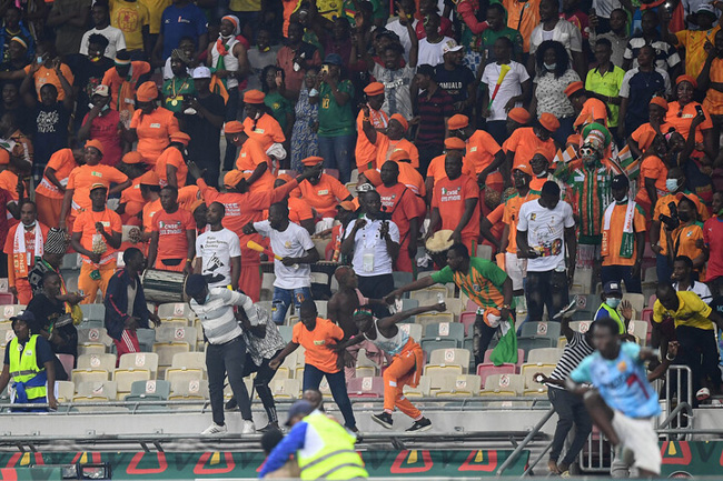 Ivory coast supporters run to invade the pitch during the Group E Africa Cup of Nations (CAN) 2021 football match between Ivory Coast and Algeria at Stade de Japoma in Douala on January 20, 2022. (Photo by CHARLY TRIBALLEAU / AFP)