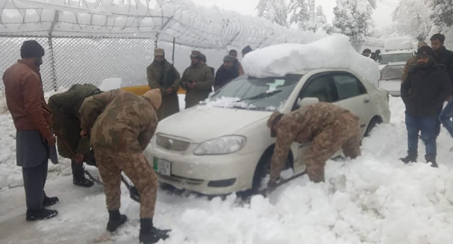 In this handout photograph released by Pakistan's Inter Services Public Relations (ISPR) on January 8, 2022 shows army soldiers take part in a rescue operation to clear a road covered with snow in Murree, around 70 kilometres (45 miles) northeast of the capital, Islamabad after an incident where at least 21 people died in an enormous traffic jam caused by tens of thousands of visitors thronging to a Pakistani hill town to see unusually heavy snowfall. Inter Services Public Relations / AFP