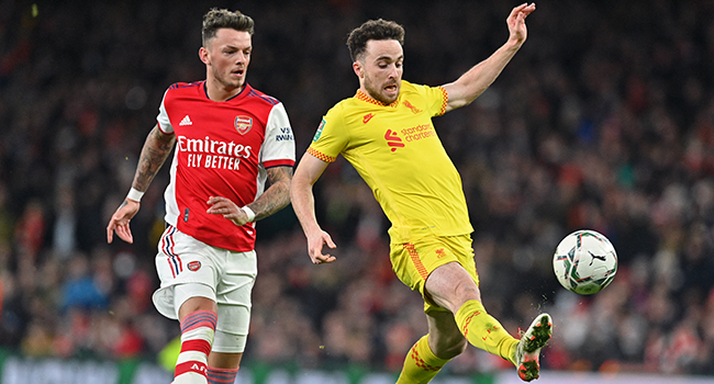 Liverpool's Portuguese striker Diogo Jota (R) shoots to score his team's second goal as Arsenal's English defender Ben White (L) chases back during the English League Cup semi-final second leg football match between Arsenal and Liverpool at the Emirates Stadium, in London on January 20, 2022. JUSTIN TALLIS / AFP