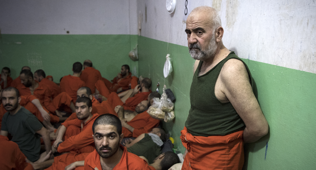 This file photo taken on October 26, 2019, shows men suspected of being affiliated with the Islamic State (IS) group, gathered in a cell of the Sinaa prison in the Ghwayran neighbourhood of the northeastern Syrian city of Hasakeh. FADEL SENNA / AFP