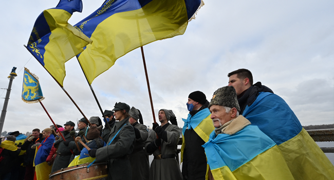 People form a symbolic human chain on a bridge across the Dnieper river in Kyiv, to mark the Day of Unity of Ukraine, on January 22, 2022. Sergei SUPINSKY / AFP
