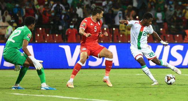 Burkina Faso's forward Dango Ouattara (R) shoots to score his team's first goal during the Africa Cup of Nations (CAN) 2021 quarter final football match between Burklina Faso and Tunisia at Stade Roumde Adjia in Garoua on January 29, 2022. Daniel BELOUMOU OLOMO / AFP