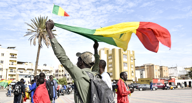 A protester holds a flag of Mali during a demonstration to support Mali on Obelisk Plazza in Dakar, on January 28, 2022. SEYLLOU / AFP