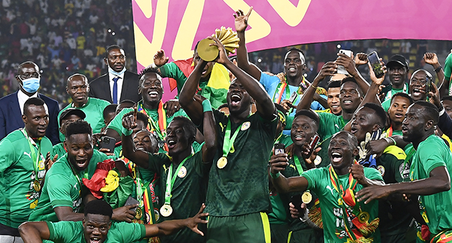 Senegal's players celebrate with the trophy after winning the Africa Cup of Nations (CAN) 2021 final football match between Senegal and Egypt at Stade d'Olembe in Yaounde on February 6, 2022. CHARLY TRIBALLEAU / AFP