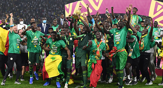 Senegal's players celebrate with the trophy after winning the Africa Cup of Nations (CAN) 2021 final football match between Senegal and Egypt at Stade d'Olembe in Yaounde on February 6, 2022. CHARLY TRIBALLEAU / AFP