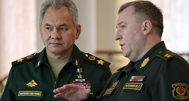 Russia's Defence Minister Sergei Shoigu (L) speaks with his Belarus counterpart Viktor Khrenin (R) prior to a meeting with Belarus President in Minsk on February 3, 2022. Maxim GUCHEK / BELTA / AFP