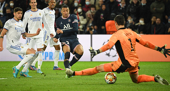 Paris Saint-Germain's French forward Kylian Mbappe (C) shoots and scores a goal during the UEFA Champions League round of 16 first leg football match between Paris Saint-Germain (PSG) and Real Madrid at the Parc des Princes stadium in Paris on February 15, 2022. Alain JOCARD / AFP