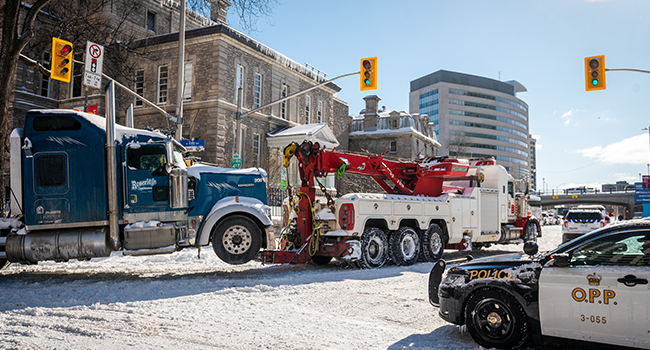 A protest trucks is towed as police begin to clear demonstrators against Covid-19 mandates in Ottawa on February 18, 2022. ANDREJ IVANOV / AFP