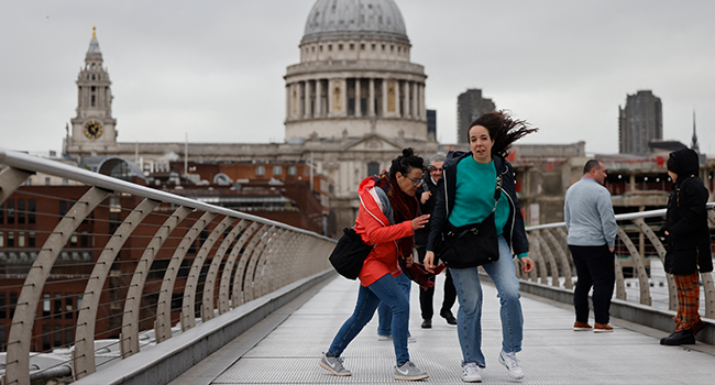 Pedestrians struggle against the high winds they cross The Millennium Bridge, near St Paul's Cathedral in central London, on February 18, 2022, as Storm Eunice batters the country. Tolga Akmen / AFP