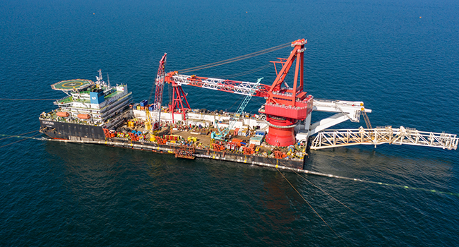 This undated File handout picture taken in September 2021 and provided by Nord Stream 2 AG, shows specialists on the laybarge Fortuna performing an above water tie-in during the final stage of Nord Stream 2 pipeline construction in the Baltic Sea. Handout / Nord Stream 2 AG / AFP