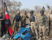 This photo, released by the Nigerian Army on March 26, 2022, shows troops standing beside what the army says are ruins of crashed Alpha Jet aircraft (NAF475).