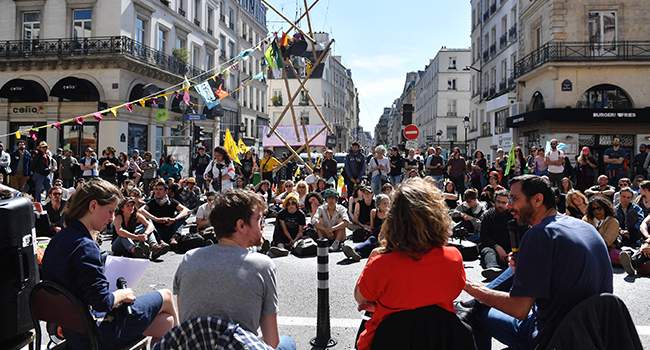 Activits of the climate change action group Extinction Rebellion block the Paris Grand Boulevard during a demonstration in Paris, on April 16 2022. JULIEN DE ROSA / AFP