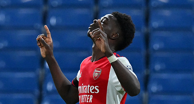 Arsenal's English midfielder Bukayo Saka celebrates after scoring their fourth goal from the penalty spot during the English Premier League football match between Chelsea and Arsenal at Stamford Bridge in London on April 20, 2022. Arsenal won the game 4-2. Glyn KIRK / AFP