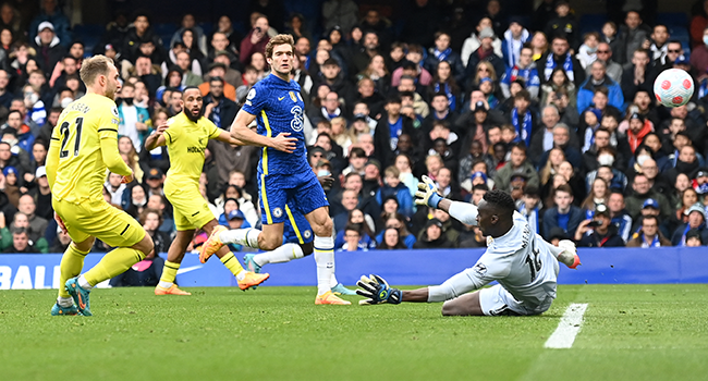 Brentford's Danish midfielder Christian Eriksen scores past Chelsea's French-born Senegalese goalkeeper Edouard Mendy (R) during the English Premier League football match between Chelsea and Brentford at Stamford Bridge in London on April 2, 2022. Glyn KIRK / AFP