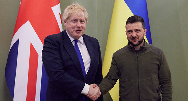 This handout picture taken and released on April 9, 2022 by Ukrainian Presidential Press Service shows Ukrainian President Volodymyr Zelensky (R) shaking hands with British Prime Minister Boris Johnson ahead of their meeting in Kyiv. Stringer / UKRAINIAN PRESIDENTIAL PRESS SERVICE / AFP