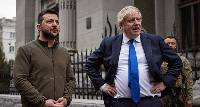 A handout photo released by the Ukrainian Presidential Press Service shows British Prime Minister Boris Johnson (R) and Ukrainian President Volodymyr Zelensky (L) speaking after walking in central Kyiv, on April 9, 2022. Stringer / UKRAINIAN PRESIDENTIAL PRESS SERVICE / AFP