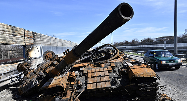 A car drives past a burnt Russian tank on a road west of Kyiv, on April 7, 2022, during Russia's military invasion launched on Ukraine. Genya SAVILOV / AFP