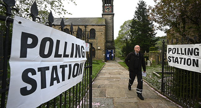 A voter walks out of Holy Trinity Church being used as a polling station in Dobcross near Manchester during local elections on May 5, 2022. Oli SCARFF / AFP