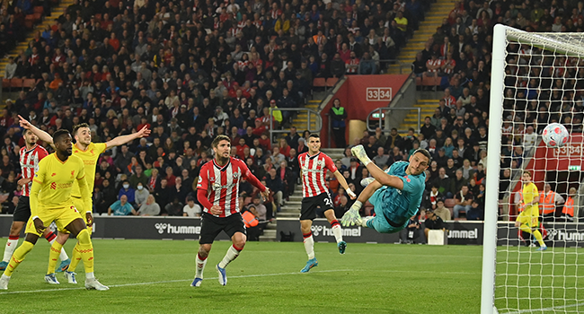 Liverpool's German-born Cameroonian defender Joel Matip (unseen) scores past Southampton's English goalkeeper Alex McCarthy (R) during the English Premier League football match between Southampton and Liverpool at St Mary's Stadium in Southampton, southern England on May 17, 2022. Glyn KIRK / AFP