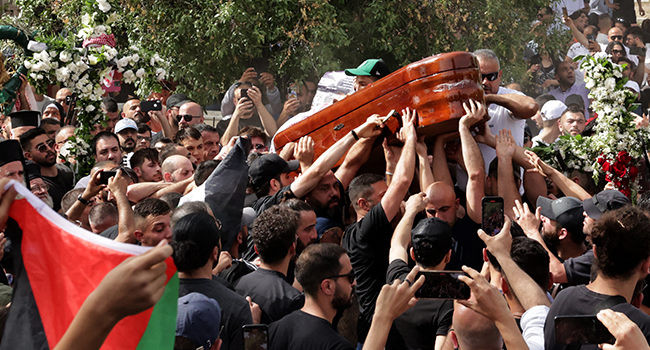 Mourners carry the coffin of slain veteran Al-Jazeera journalist Shireen Abu Akleh during her burial at the Mount Zion Cemetery outside Jerusalem's Old City on May 13, 2022, two days after she was killed while covering an Israeli army raid in the West Bank. HAZEM BADER / AFP