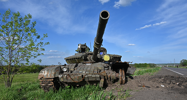 This photograph taken on May 13, 2022, shows a damaged tank on a road near the Vilkhivka village east of Kharkiv, amid Russian invasion of Ukraine. SERGEY BOBOK / AFP