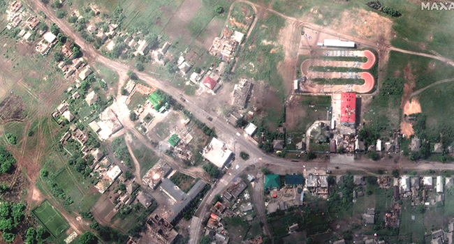 This satellite image released by Maxar Technologies on May 27 shows damaged buildings and tank on the road in Lyman, Ukraine, May 25, 2022. Satellite image ©2022 Maxar Technologies / AFP