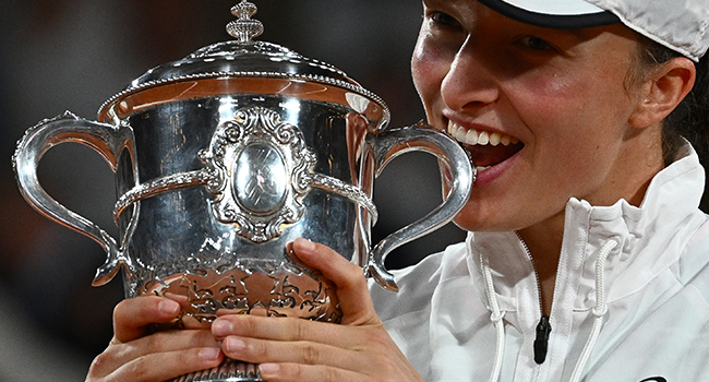 Poland's Iga Swiatek poses with the trophy after winning against US' Coco Gauff at the end of their women's single final match on day fourteen of the Roland-Garros Open tennis tournament at the Court Philippe-Chatrier in Paris on June 4, 2022. Anne-Christine POUJOULAT / AFP