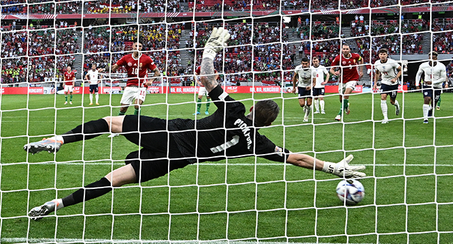 Hungary's midfielder Dominik Szoboszlai (C) scores the opening goal from the penalty spot past England's goalkeeper Jordan Pickford during the UEFA Nations League football match Hungary v England at the Puskas Arena in Budapest, Hungary, on June 4, 2022. Attila KISBENEDEK / AFP