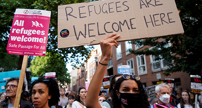 Protesters hold placards as they gather outside the Home Office in central London on June 13, 2022, to demonstrate against the UK government's intention to deport asylum-seekers to Rwanda. Niklas HALLE'N / AFP