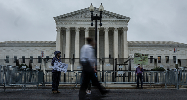 People walk past the U.S. Supreme Court Building during a rainstorm on June 23, 2022 in Washington, DC. Decisions are expected in 13 more cases before the end of the Court's current session. Anna Moneymaker/Getty Images/AFP