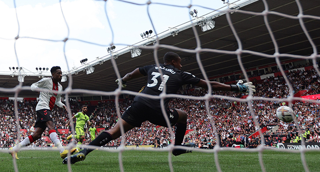 Manchester United's Portuguese midfielder Bruno Fernandes (C) scores his team's first goal past Southampton's Irish goalkeeper Gavin Bazunu during the English Premier League football match between Southampton and Manchester United at St Mary's Stadium in Southampton, southern England on August 27, 2022. (Photo by Adrian DENNIS / AFP)