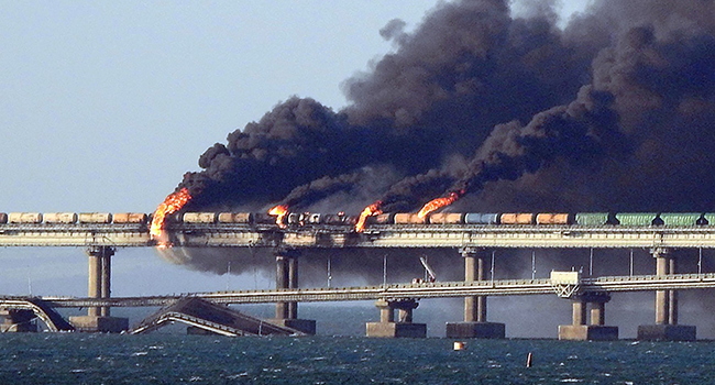 Black smoke billows from a fire on the Kerch bridge that links Crimea to Russia, after a truck exploded, near Kerch, on October 8, 2022. (Photo by AFP)