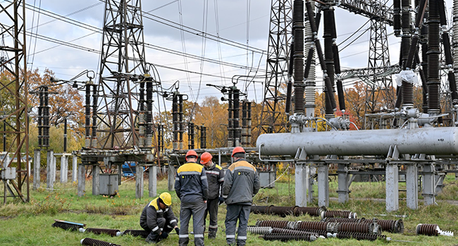 Workers repair equipments of power lines destroyed after a missile strike on a power plant, in an undisclosed location of Ukraine, on October 27, 2022, amid the Russian invasion of Ukraine. (Photo by Sergei SUPINSKY / AFP)